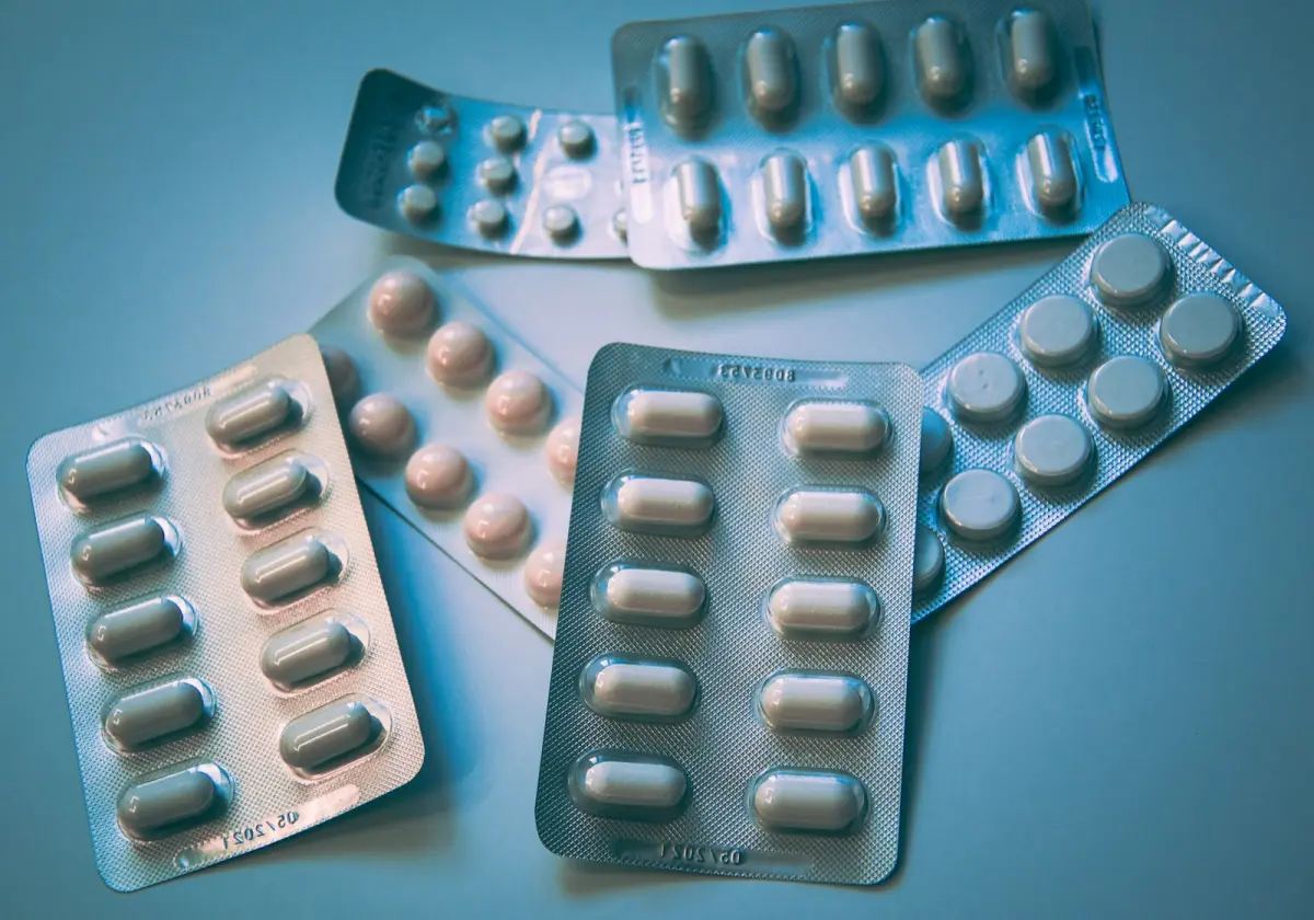 Several blister packs of tablets and capsules on a table