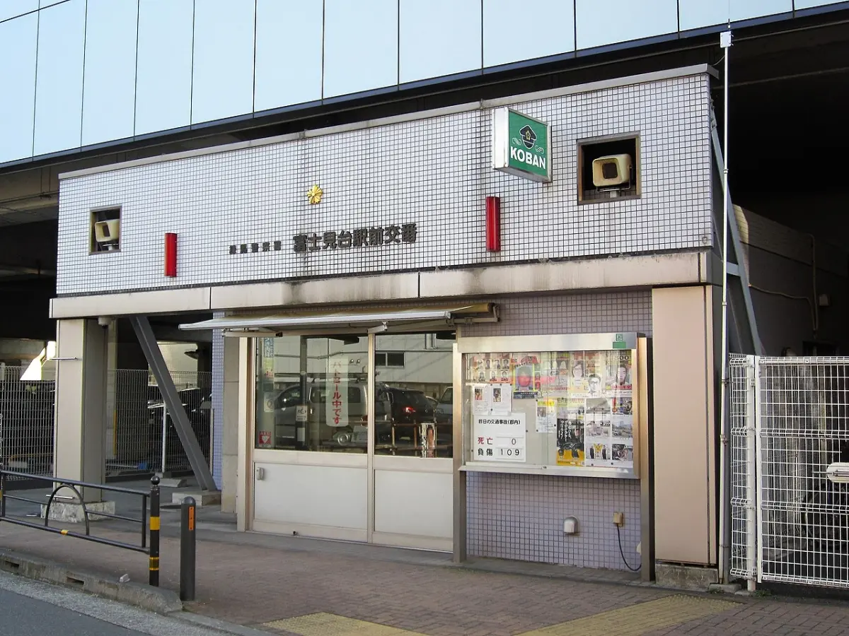 A small koban police box beside a station in Tokyo, with a green KOBAN sign