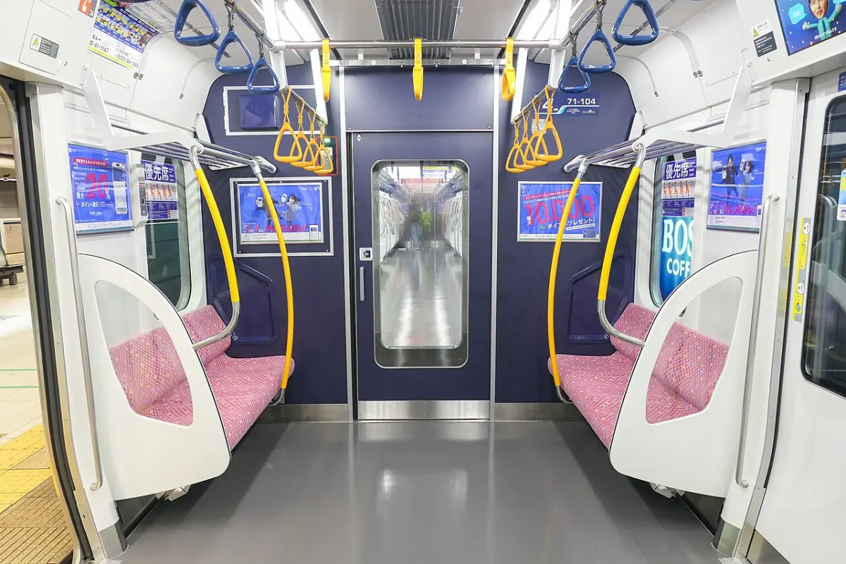 Priority seats at the end of a Rinkai Line train car in Tokyo, set apart with a different seat color