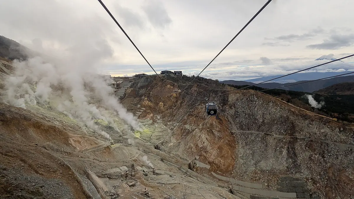 Hakone Ropeway gondola passing over the steaming volcanic valley of Owakudani