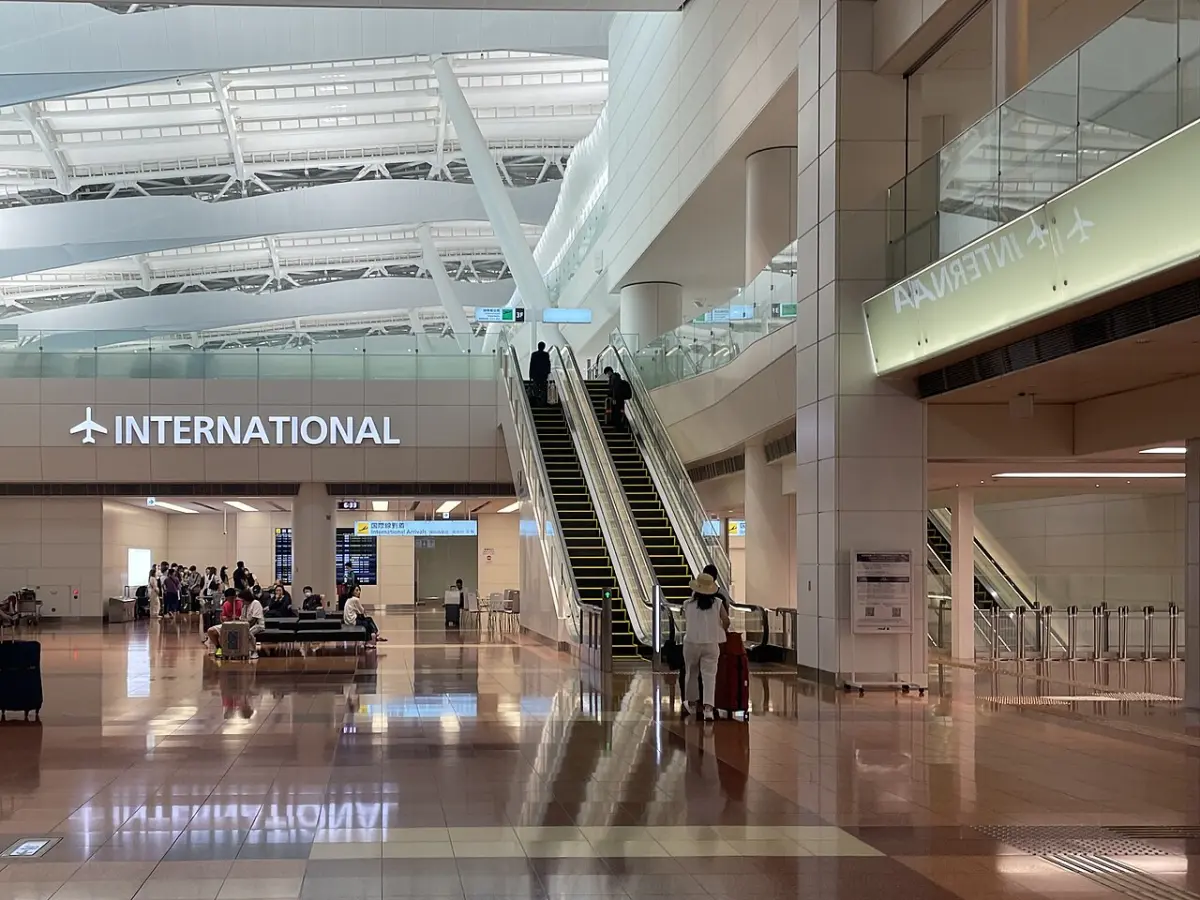 International flight section inside Haneda Airport Terminal 2 with escalators and travelers