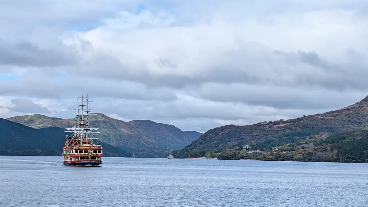 Hakone pirate-themed sightseeing ship crossing Lake Ashi with mountains behind