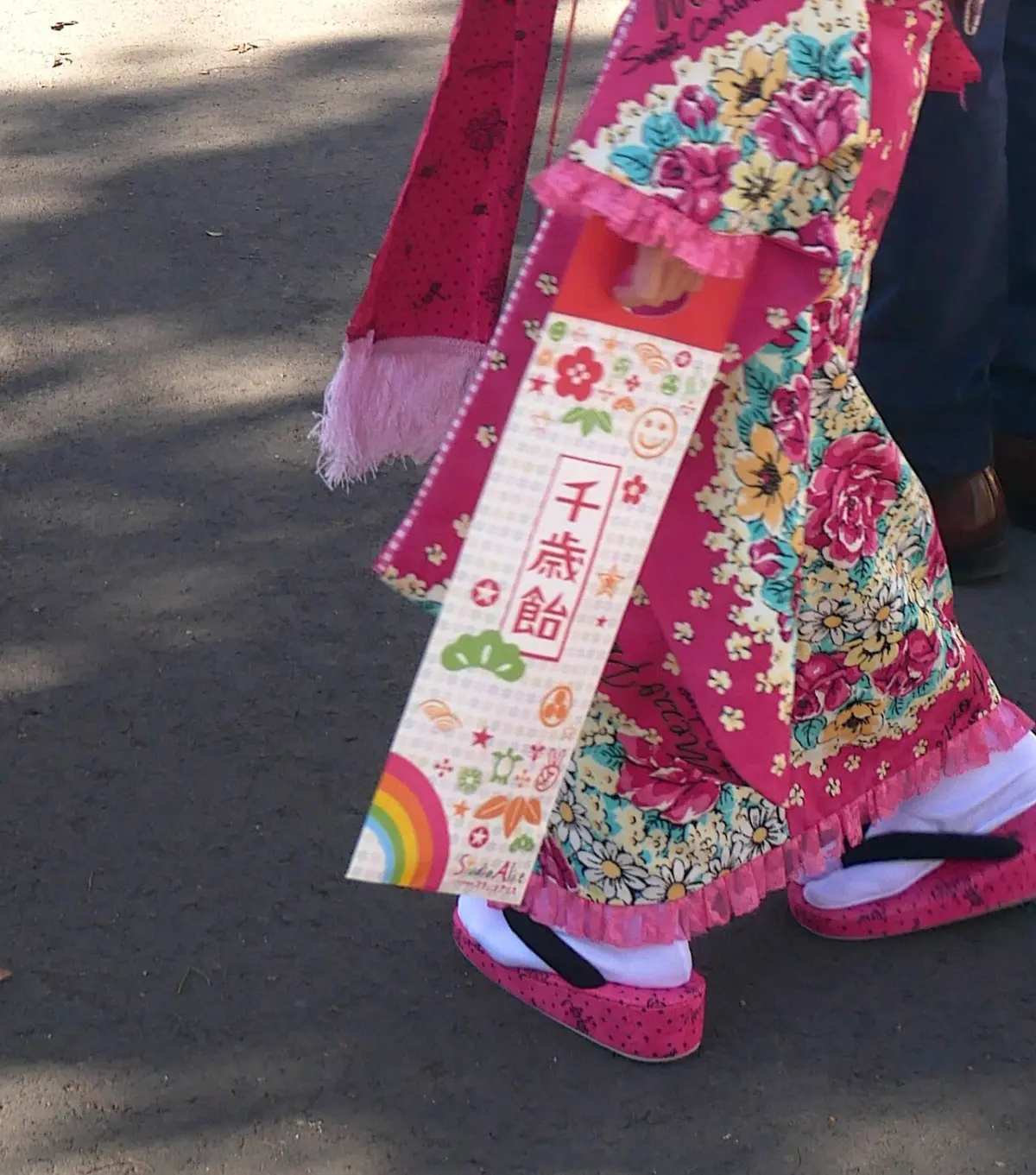 Girl in a bright kimono carrying a bag of chitose-ame candy for Shichi-Go-San