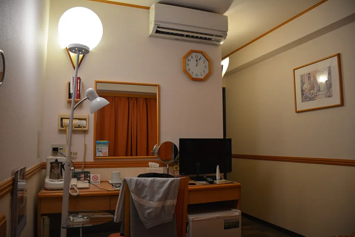 Compact Japanese business hotel room with desk, TV and kettle at a Toyoko Inn