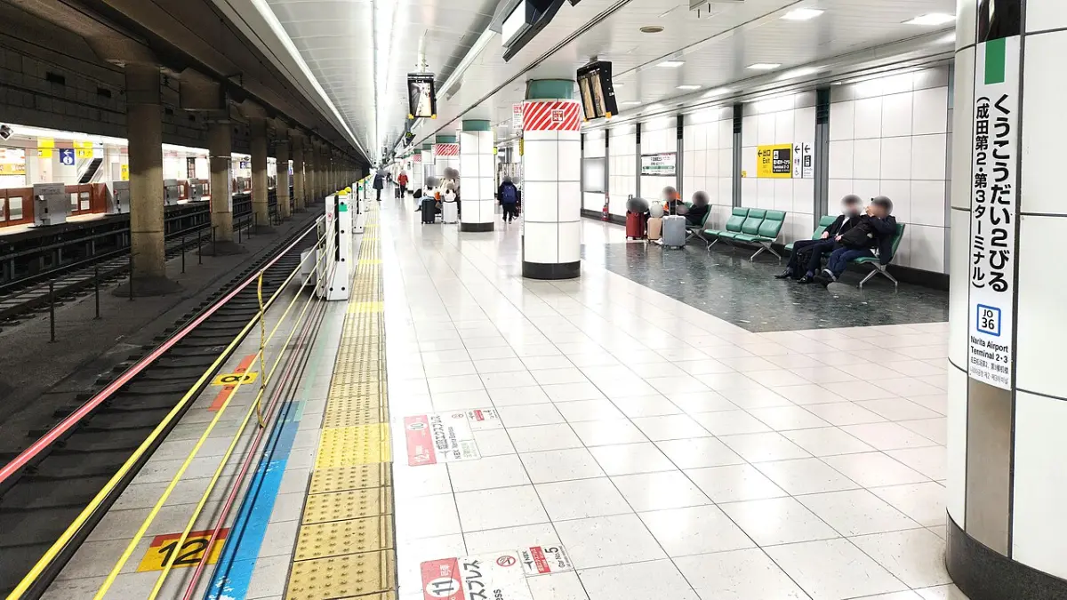 JR platform at Narita Airport Terminal 2·3 Station with travelers waiting on benches